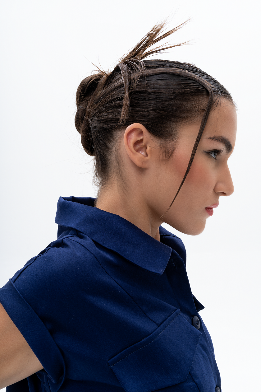 Detail shot of AKANTARA Cropped Short Sleeve Vest in navy and brown, highlighting the design elements